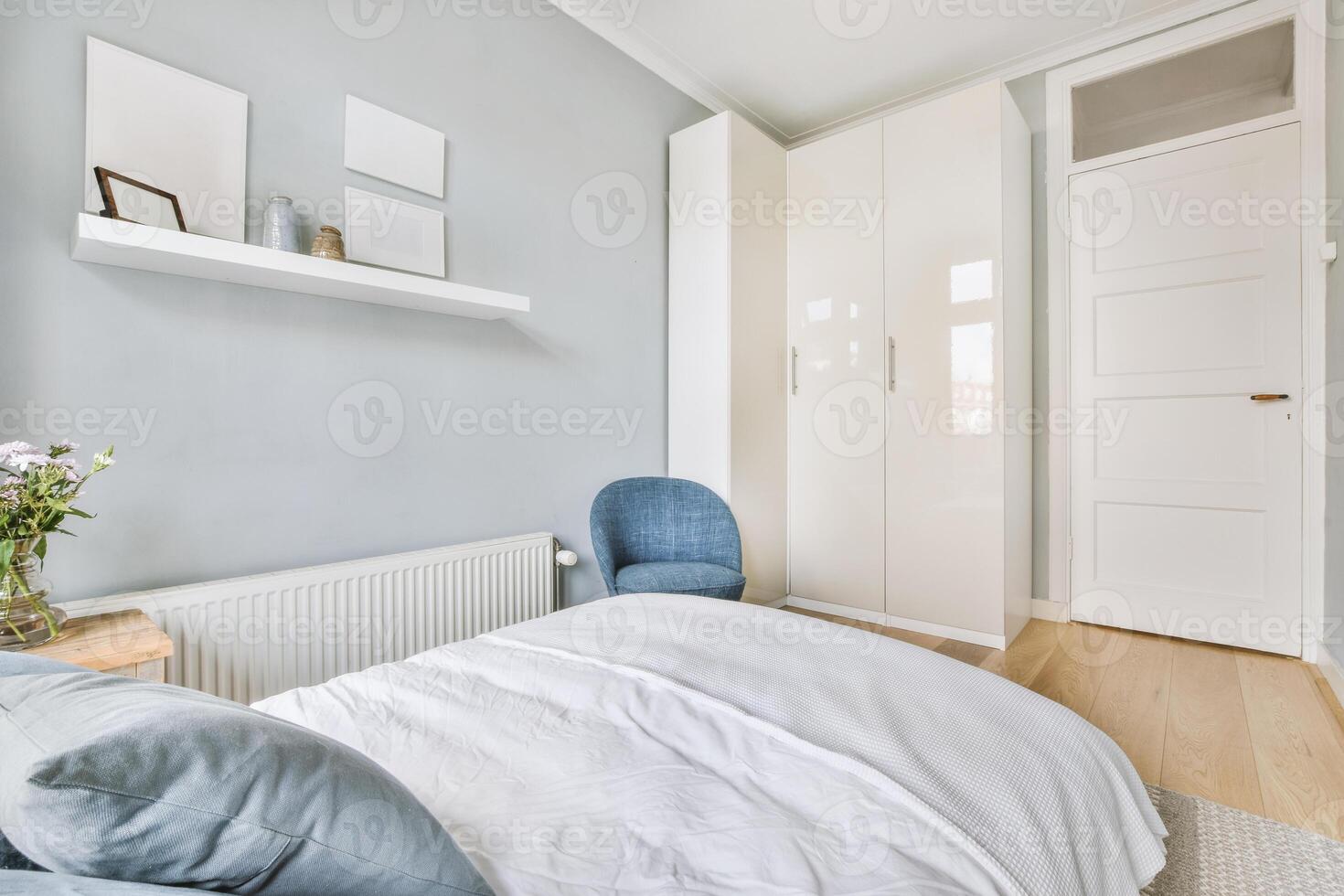 A bedroom with a bed, a chair, a dresser and a wall photo