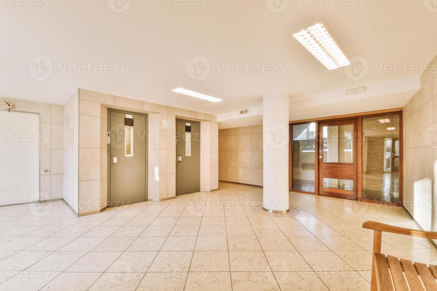 An empty hallway with two doors and a bench photo