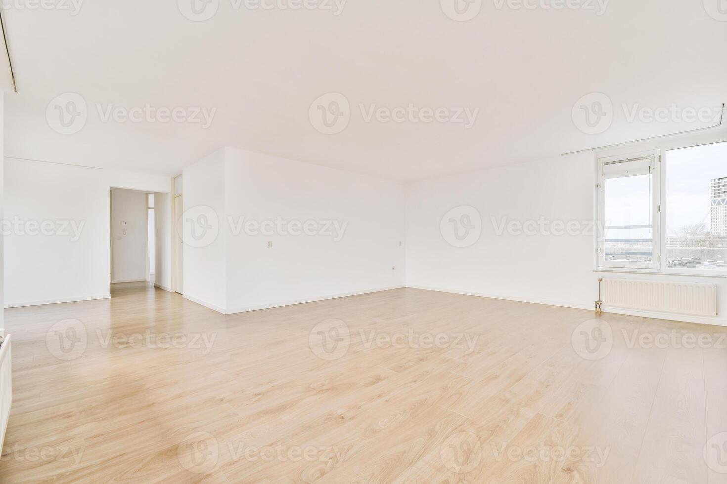 An empty room with hardwood floors and white walls photo