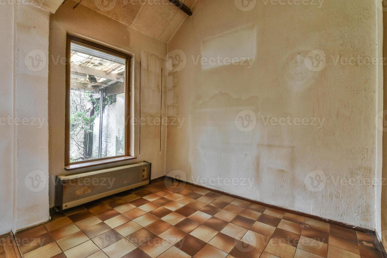 An empty room with a window and a tiled floor photo