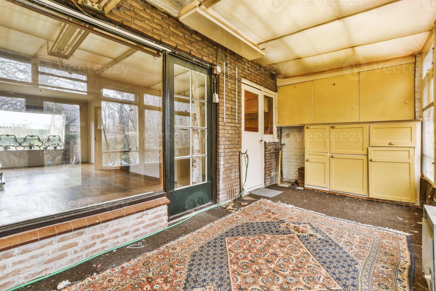 A room with a large window and a rug photo