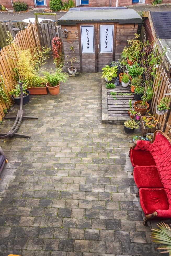A brick patio with a red couch and a table photo