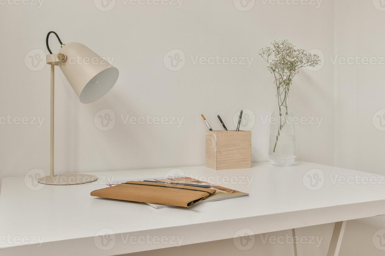 A white desk with a lamp and a book photo
