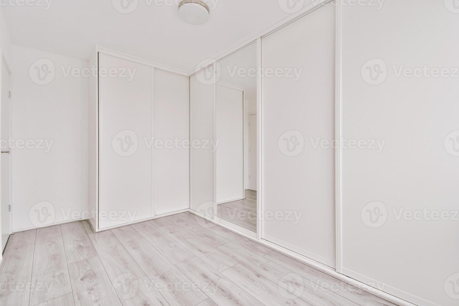 A white room with white walls and wooden floors photo