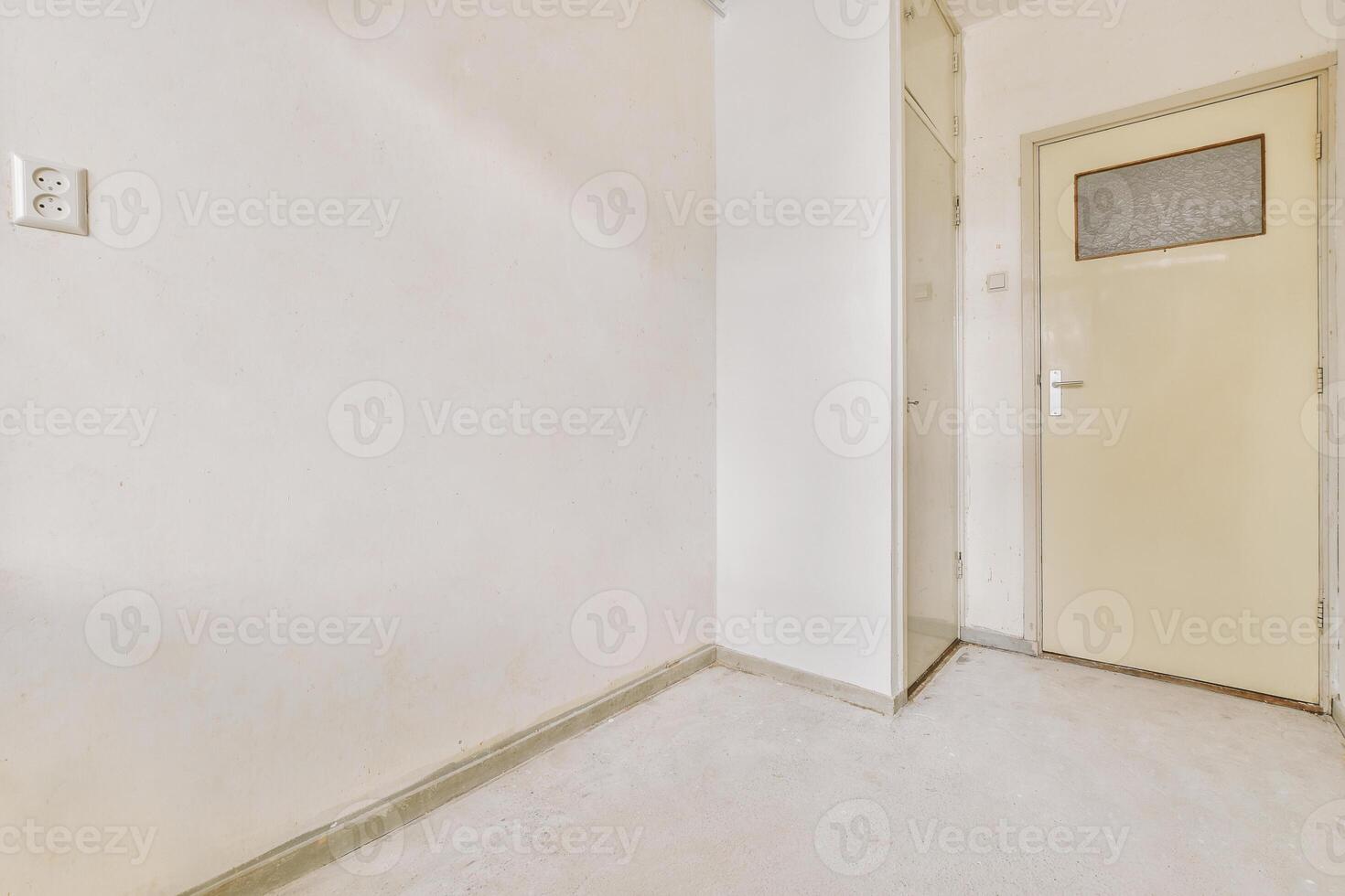 An empty room with a door and a white wall photo