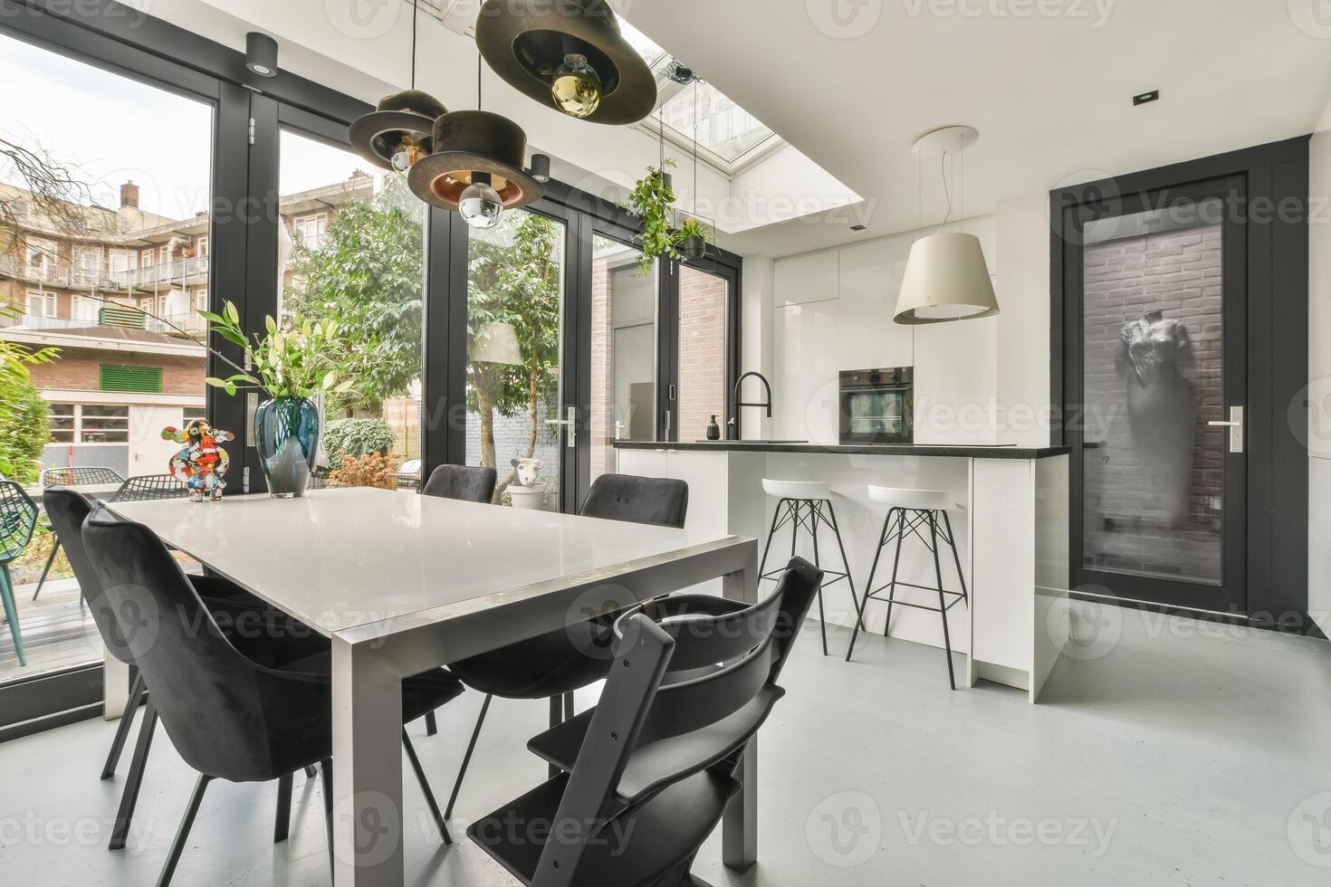 A kitchen with a table and chairs in front of a large window photo