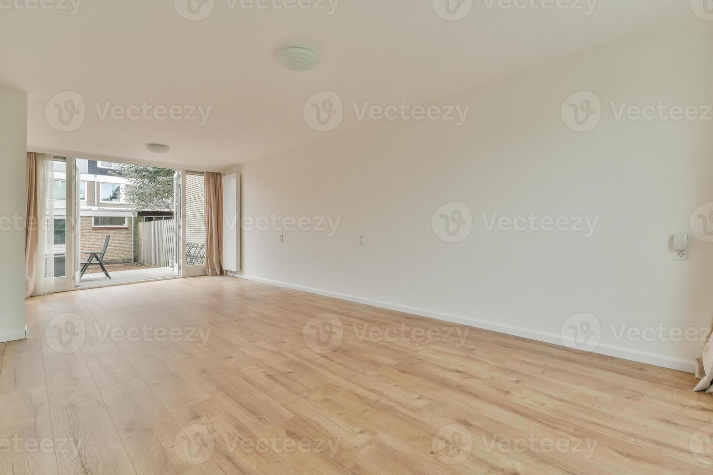An empty room with wooden floors and a sliding door photo