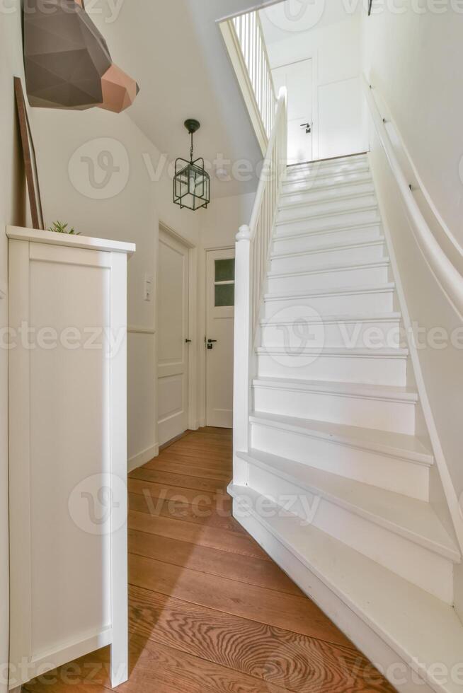 A white staircase leads to a room with a white door photo