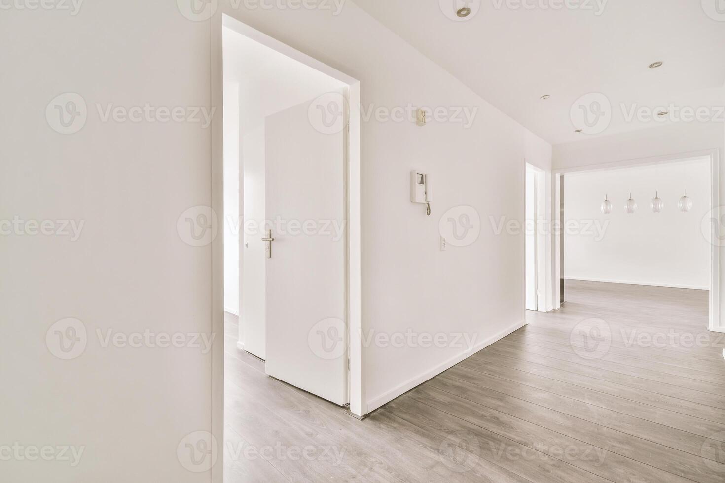 Empty white hallway with wooden floor and white walls photo