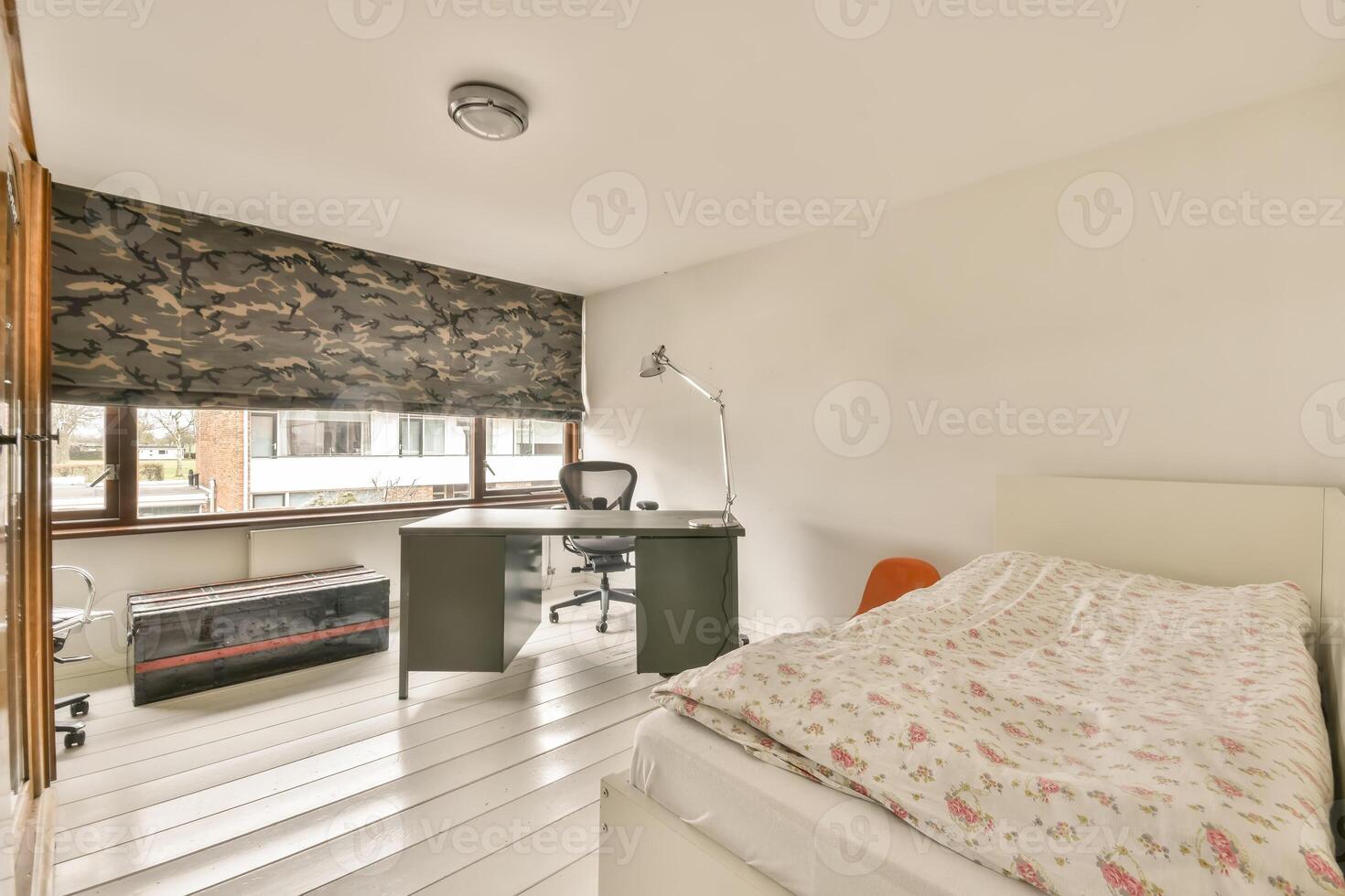 A bedroom with a desk and a bed photo