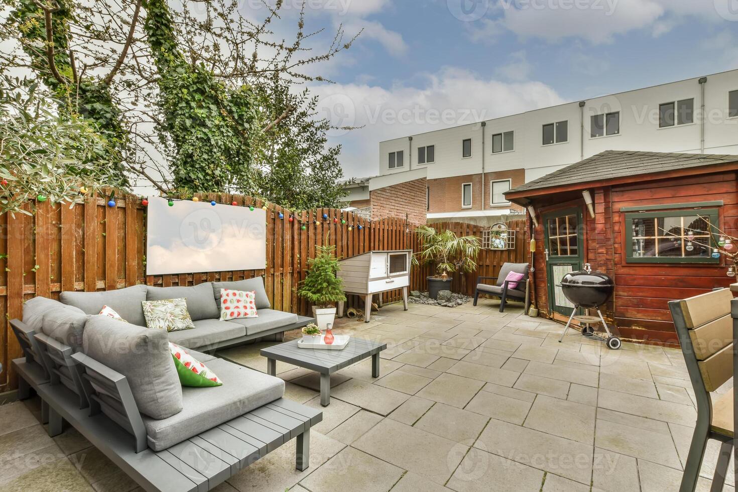 A backyard with a patio, furniture and a wooden fence photo