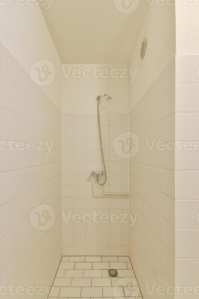 A shower with a shower head and a tiled floor photo