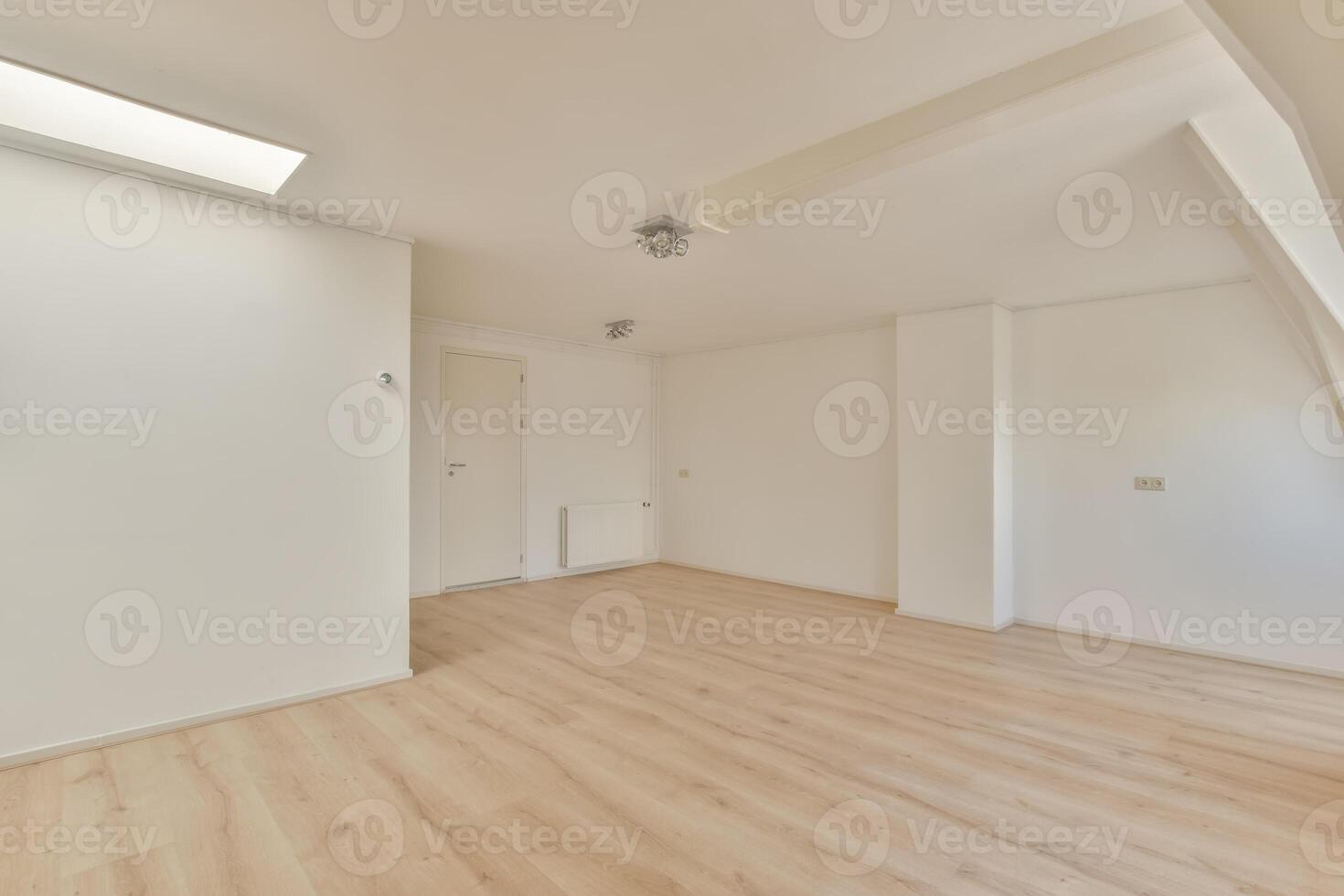 An empty room with wooden floors and white walls photo