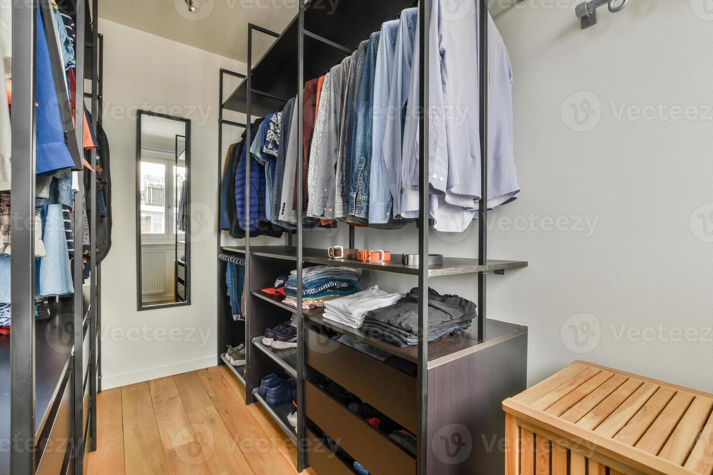 A walk - in closet with a wooden floor and a wooden shelf photo