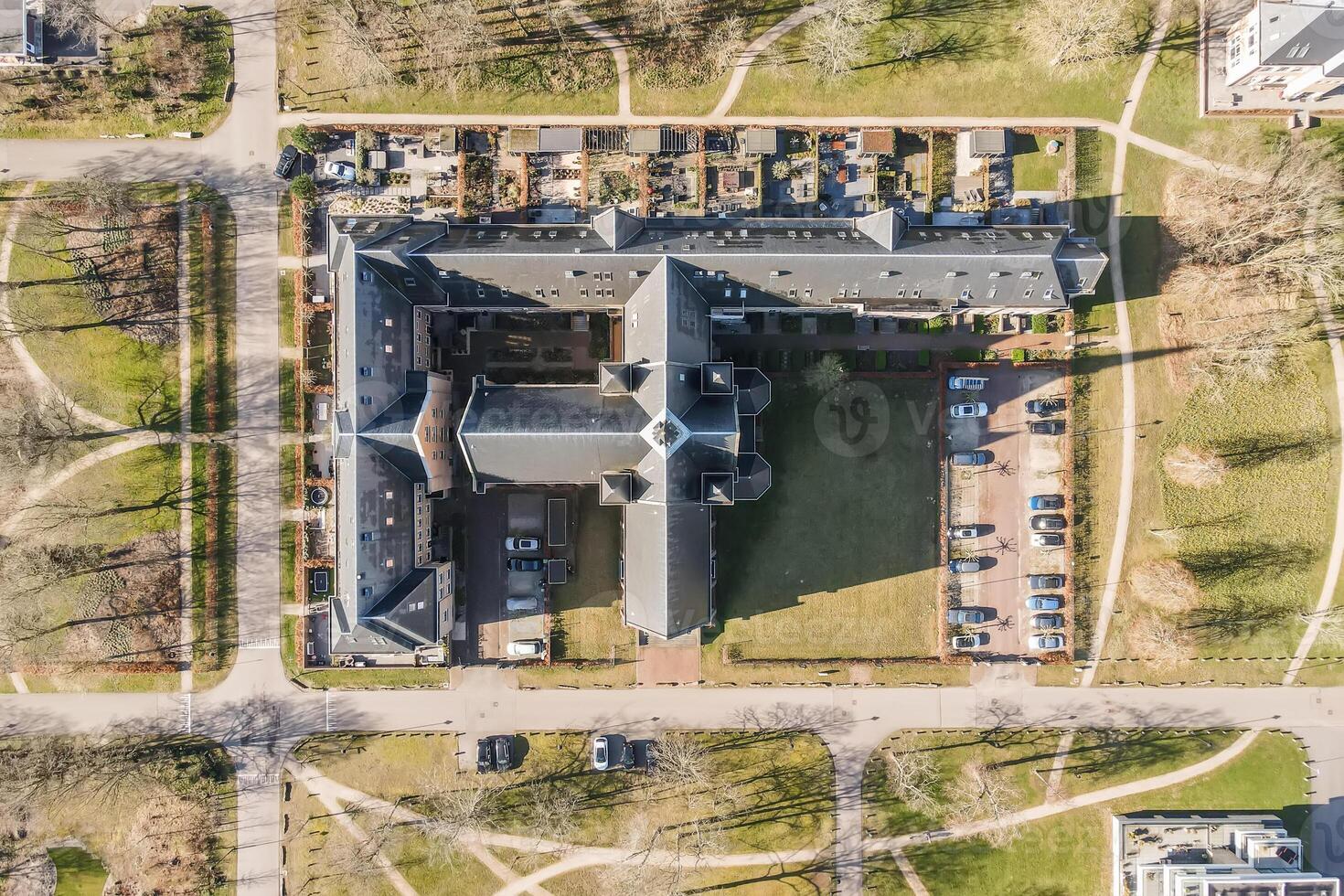 An aerial view of a large building with a lot of cars photo