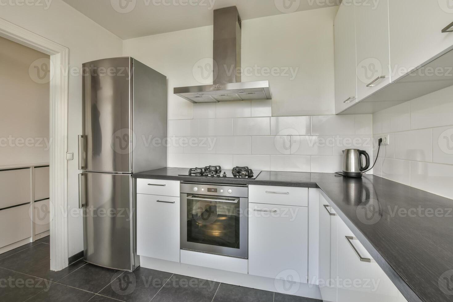 A kitchen with stainless steel appliances and black counter tops photo