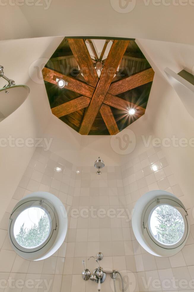 A bathroom with a shower and two windows photo