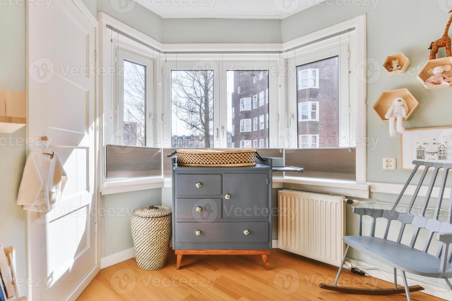 A small room with a rocking chair and a dresser photo