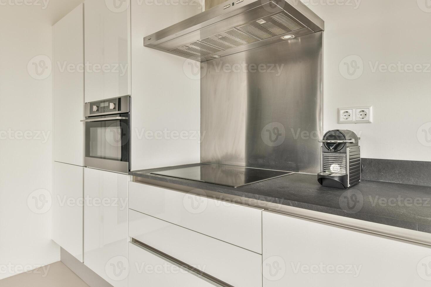 A kitchen with stainless steel appliances and a black counter top photo