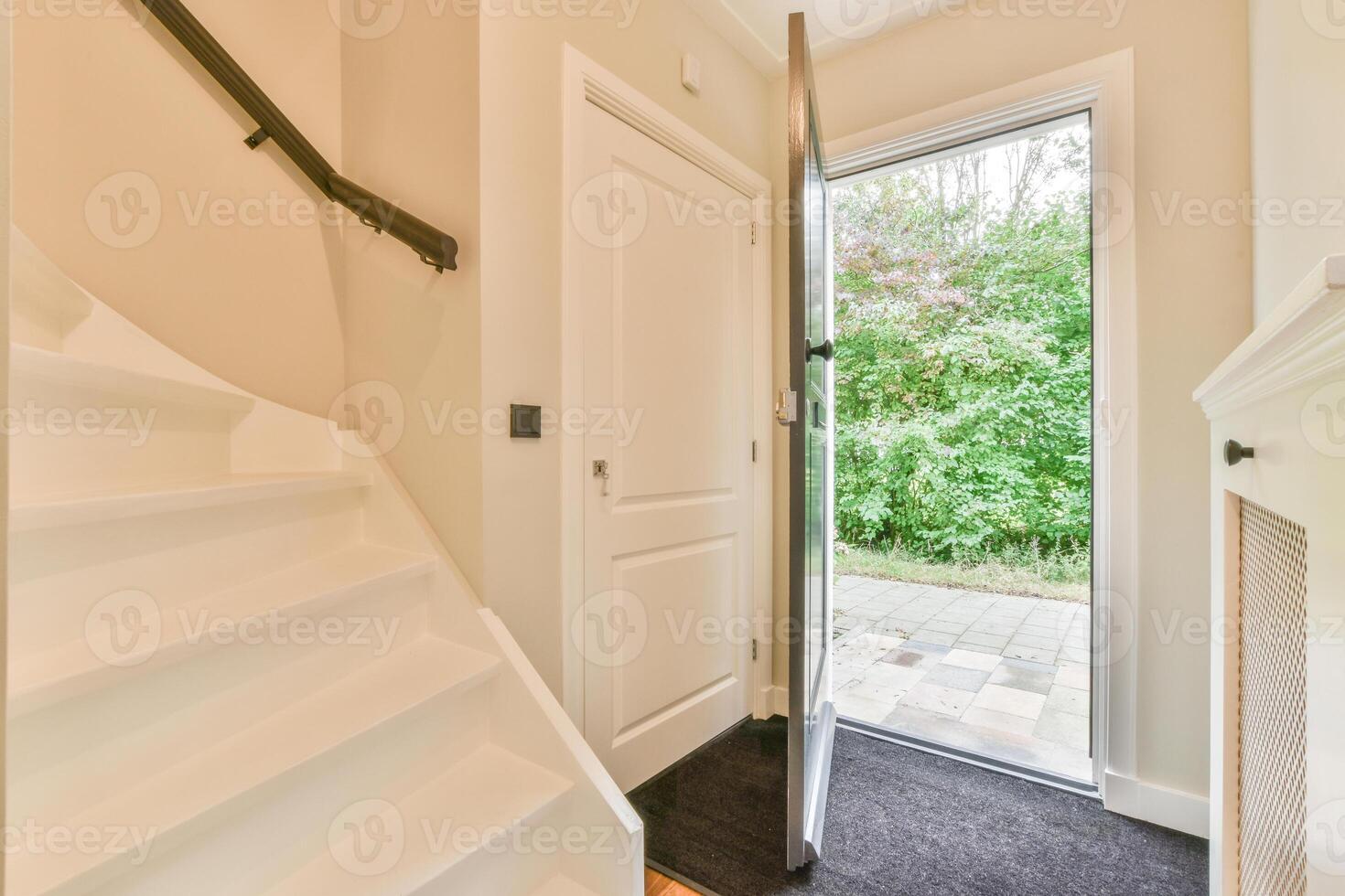A white door with a white door handle and a white staircase photo