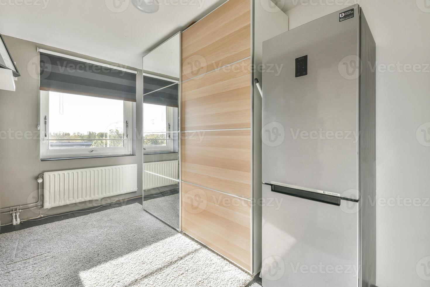 A modern apartment with a refrigerator and a sliding door photo