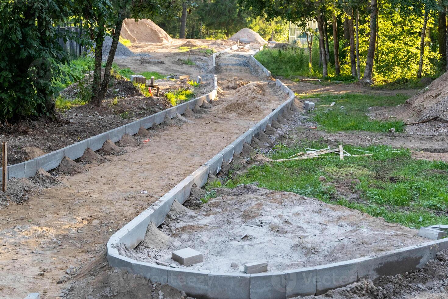 A winding pathway is being constructed with concrete curbing photo
