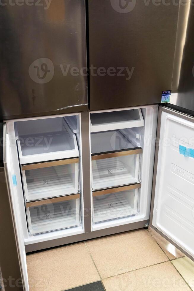The inside of a modern refrigerator shows empty shelves and drawers photo