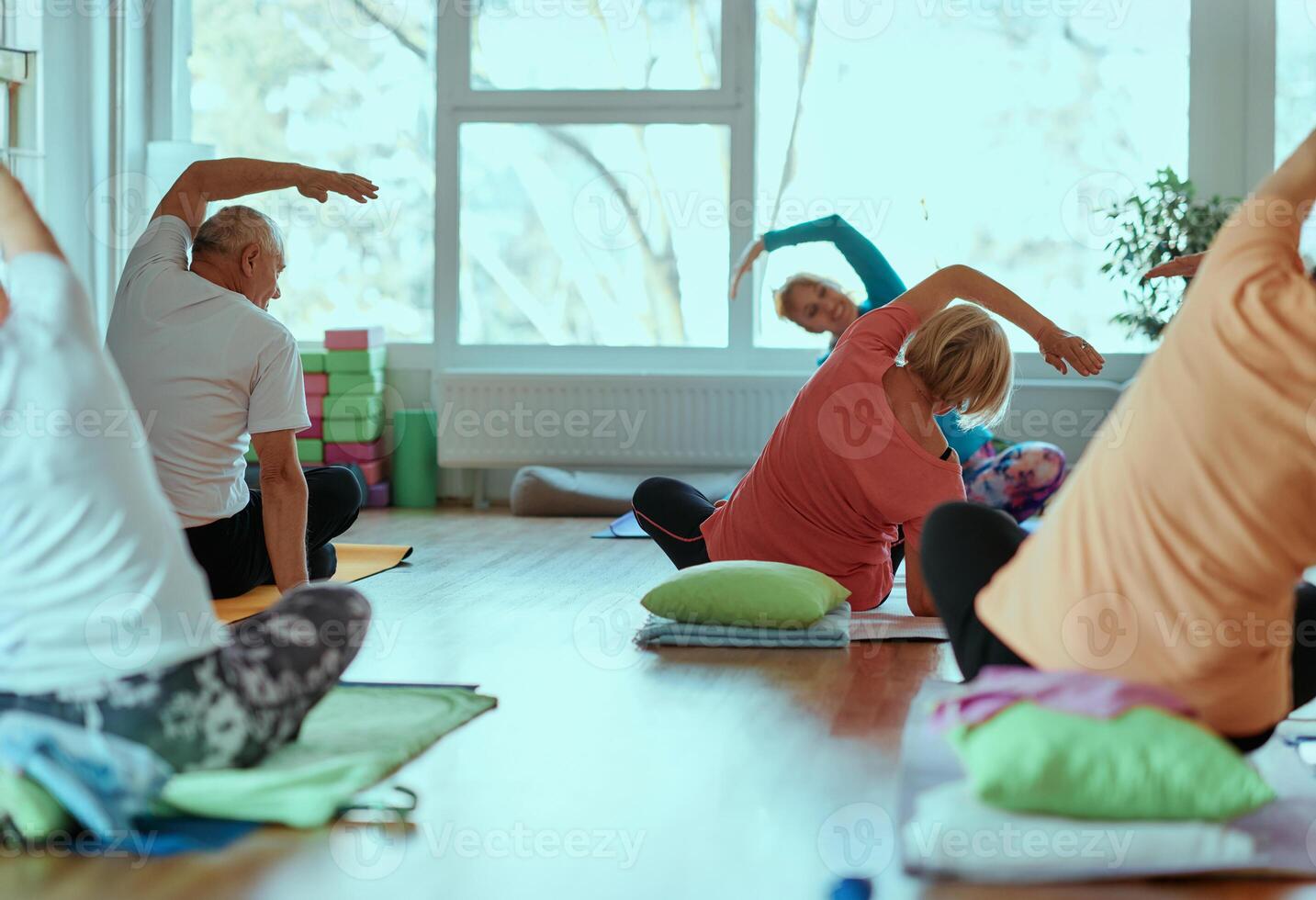 Senior Women Embrace Wellness. Yoga and Stretching in a Sunlit Space photo