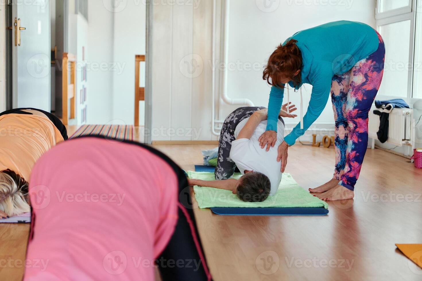 Experienced yoga instructor demonstrating safe and effective exercises for seniors to improve flexibility and balance. photo
