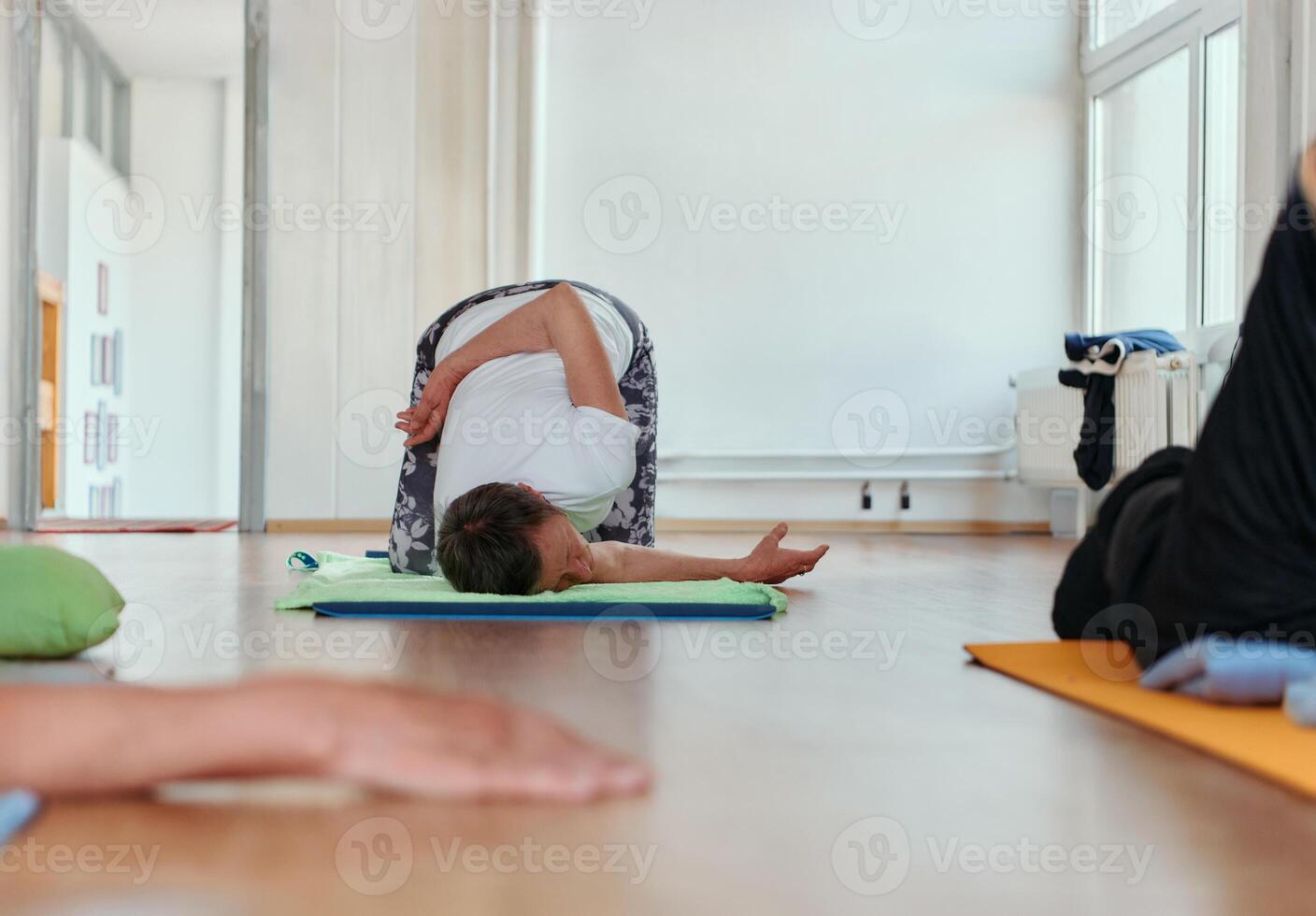 Senior Woman Practicing Back Stretches in a Sunlit Space for Optimal Health and Well Being photo