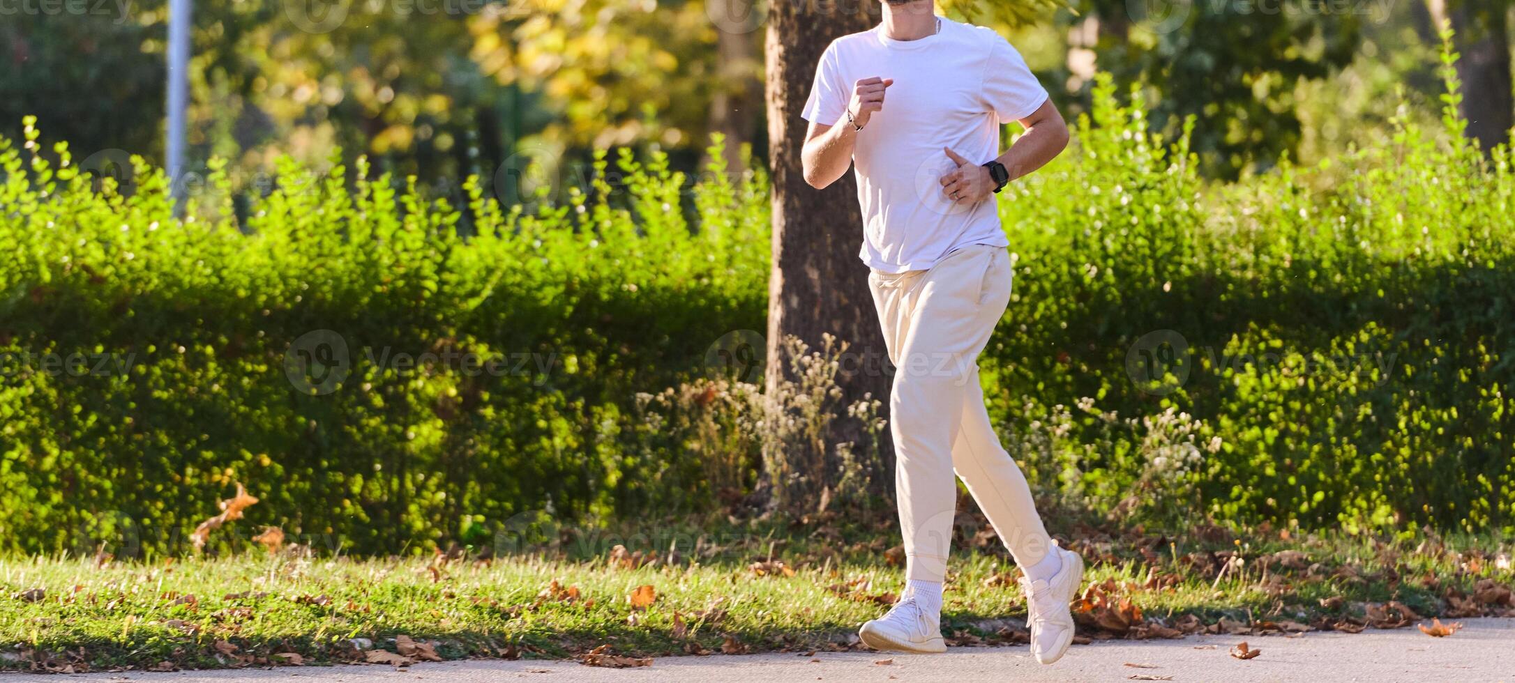 A handsome man maintains his healthy lifestyle as he runs along beautiful natural trails, embodying the essence of fitness, wellness, and vitality in the midst of scenic outdoor surroundings. photo