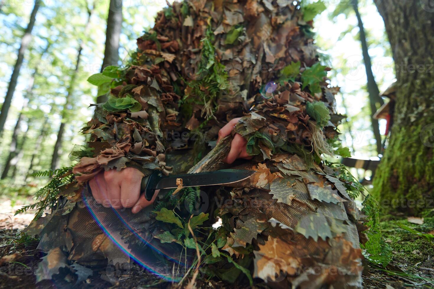 elite camouflaged sniper sharpens focus and readies for battle in the dense forest, embodying precision, stealth, and expertise as they prepare for a mission in the woodland environment photo