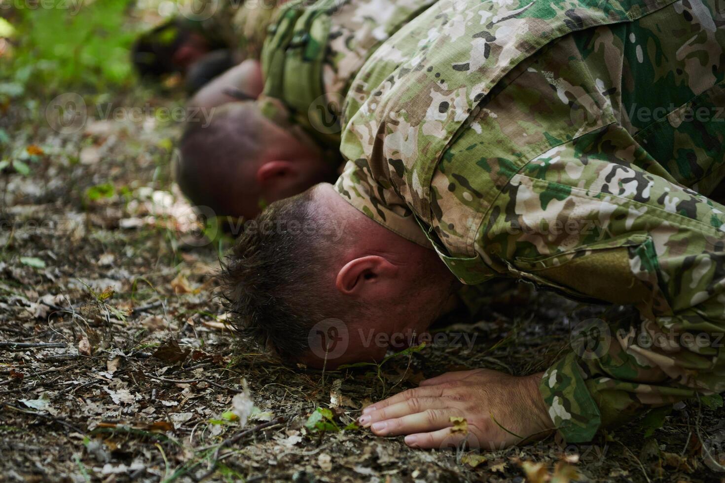 A dedicated group of soldiers engages in Islamic prayer amidst the challenging and perilous conditions of a military operation in dense forested areas photo