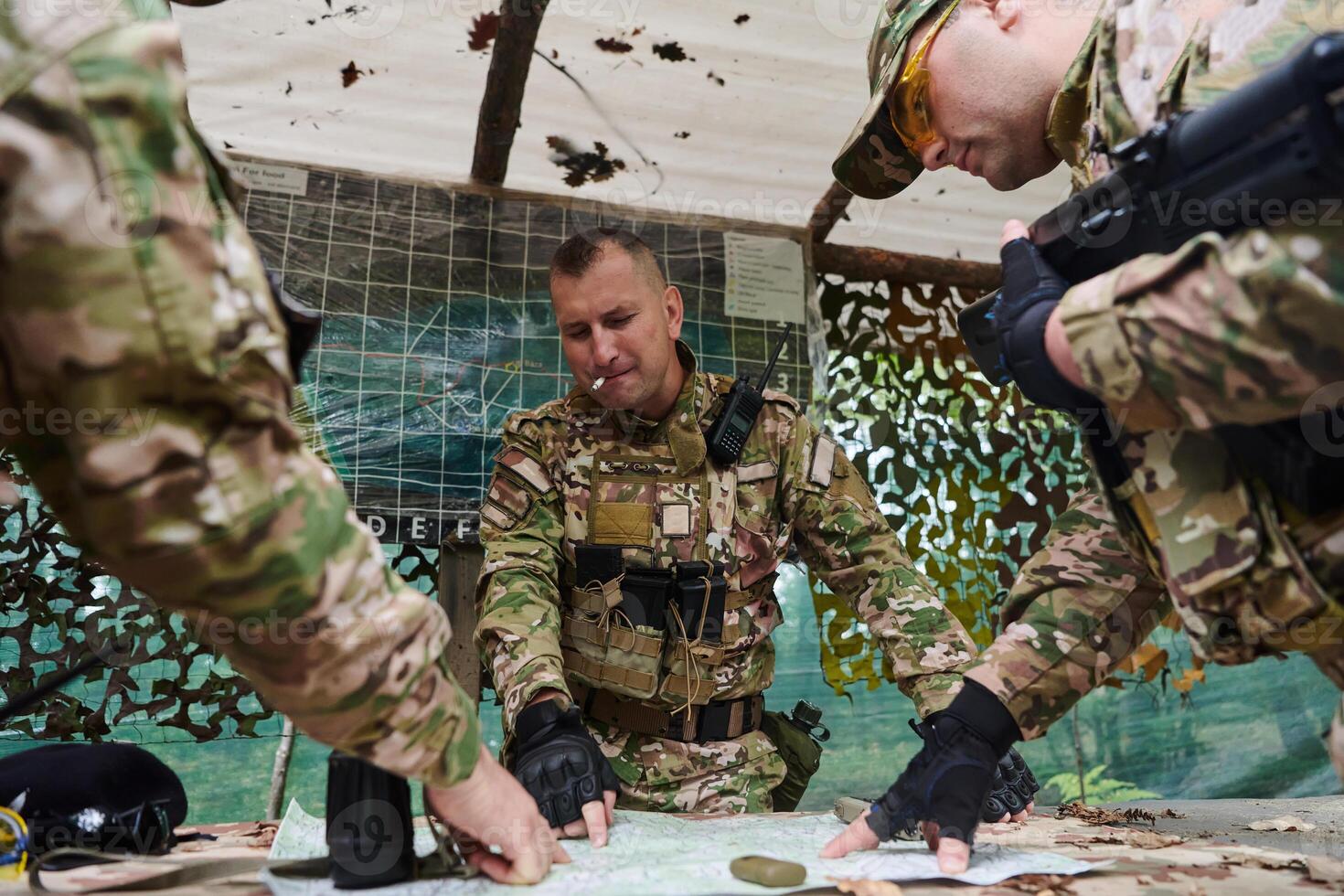 A highly trained military unit strategizes and organizes a tactical mission while studying a military map during a briefing session photo