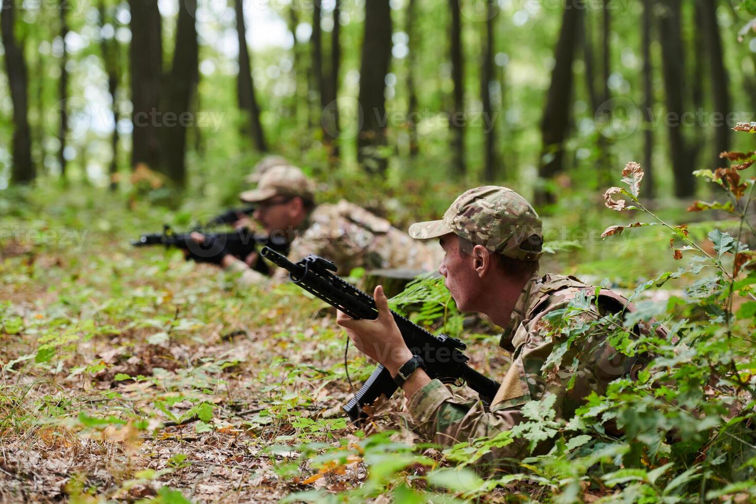 Elite soldiers stealthily maneuver through the dense forest, camouflaged in specialized gear, as they embark on a covert and strategic military mission photo