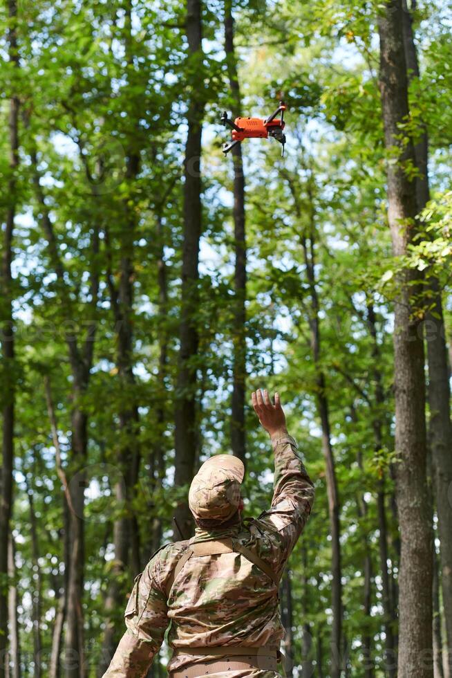 Elite military unit, equipped with state-of-the-art technology including a drone, strategically navigates and surveys dangerous wooded terrain, showcasing their precision, cooperation, and specialized photo