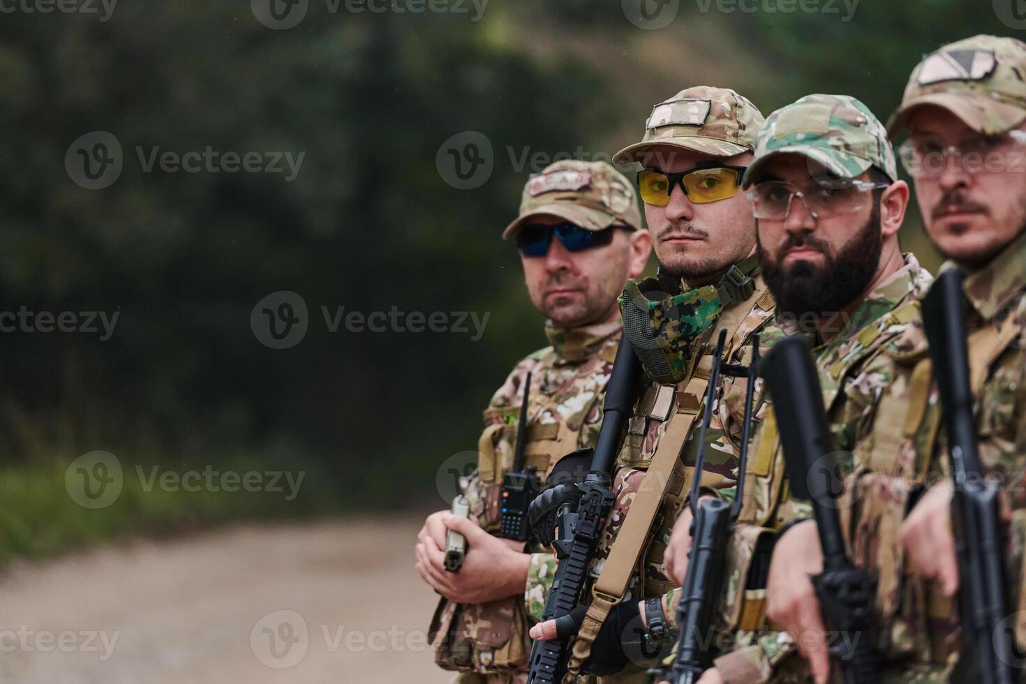 Soldier fighters standing together with guns. Group portrait of US army elite members, private military company servicemen, anti terrorist squad photo