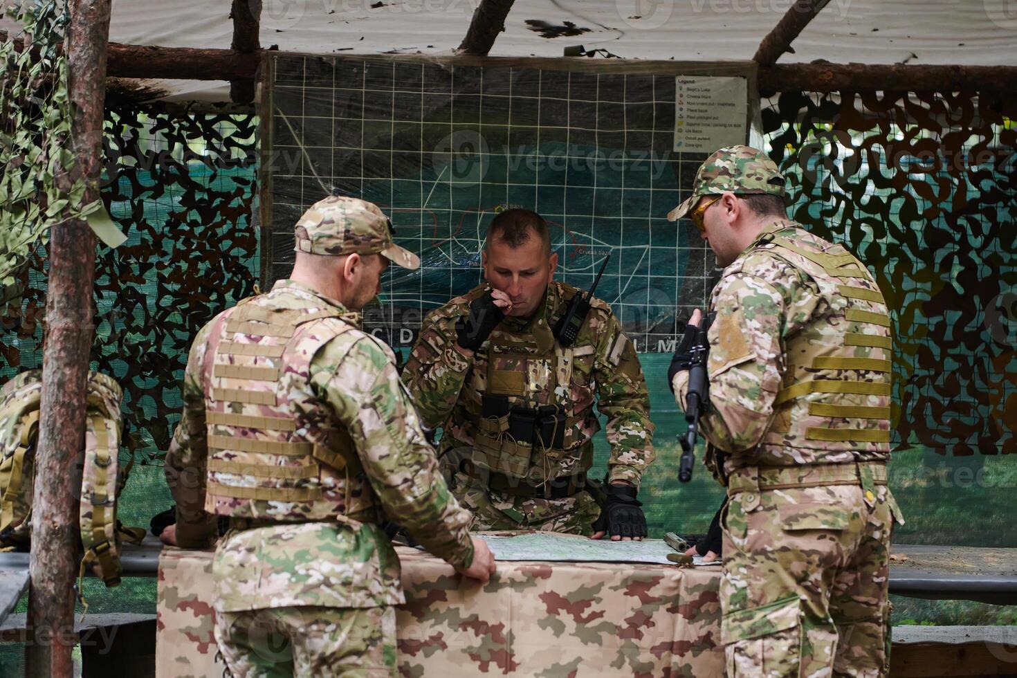 A highly trained military unit strategizes and organizes a tactical mission while studying a military map during a briefing session photo