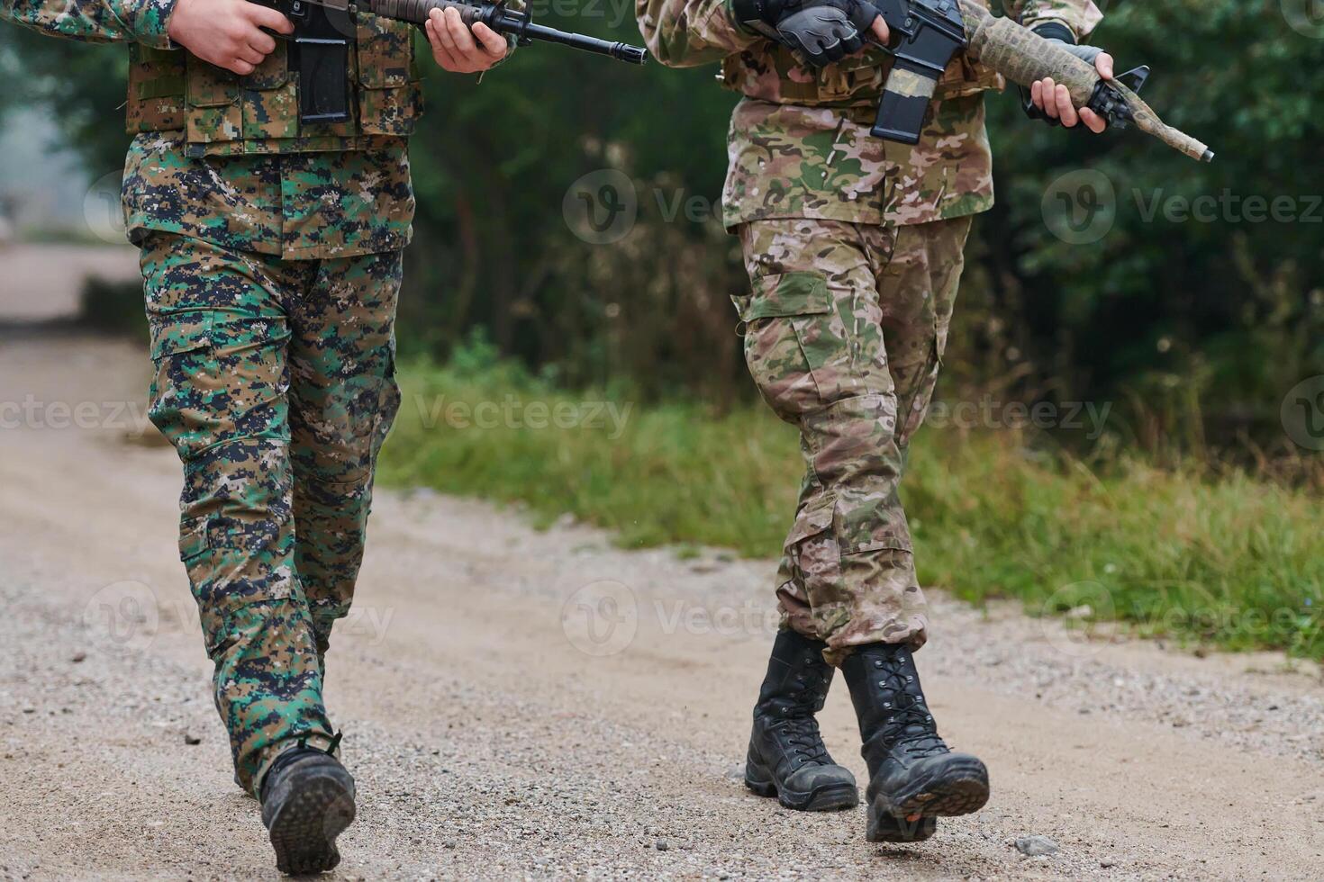 Close up photo, the resilient legs of elite soldiers, clad in camouflage boots, stride purposefully along a hazardous forest path as they embark on a high-stakes military mission photo