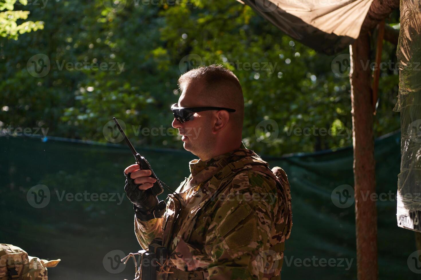 A military major employs a Motorola radio for seamless communication with his fellow soldiers during a tactical operation, showcasing professionalism and strategic coordination photo