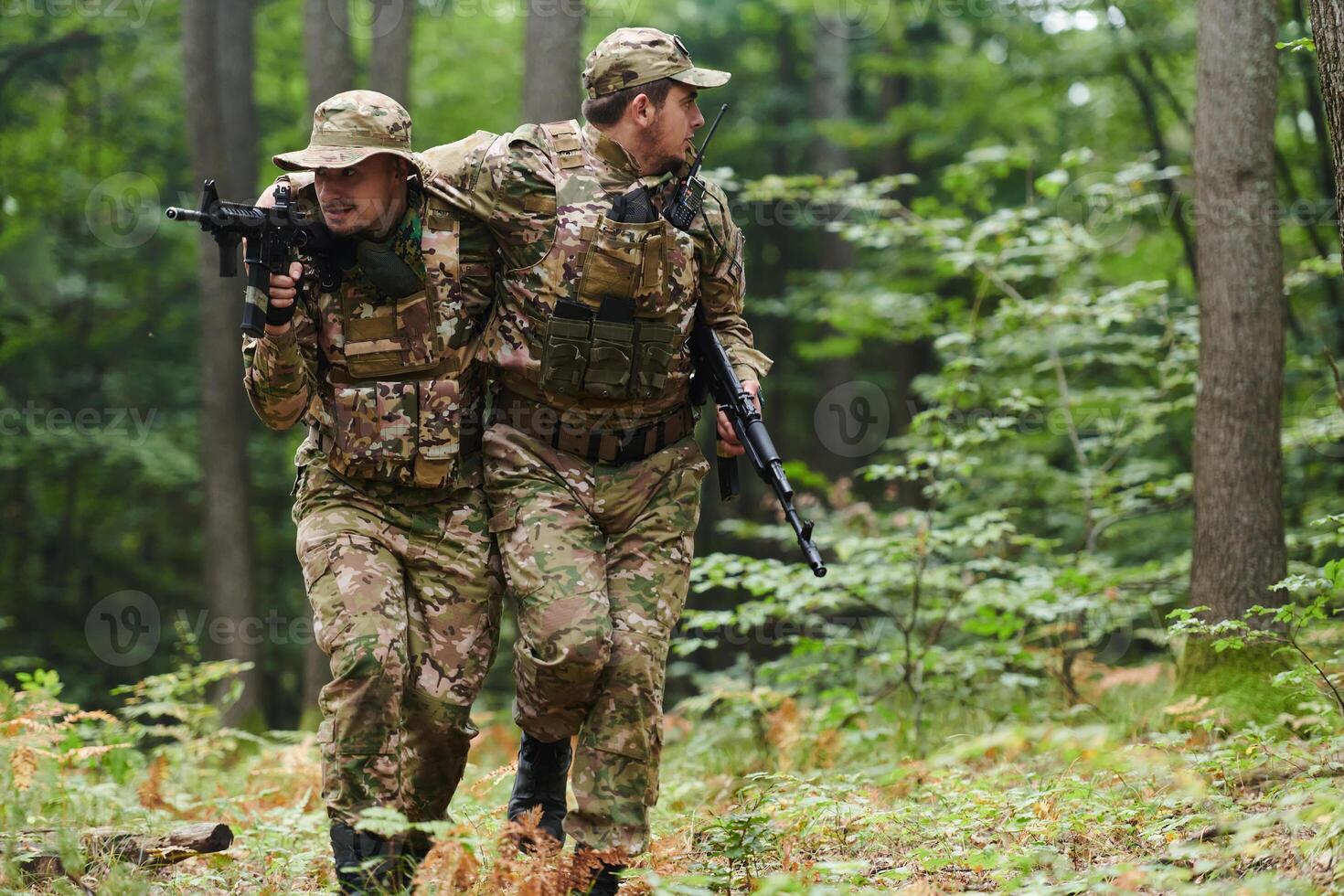 Elite soldier displays unwavering camaraderie and compassion as he aids his injured comrade, skillfully extracting him from the forest with a stretcher, showcasing the profound bond and selflessness photo