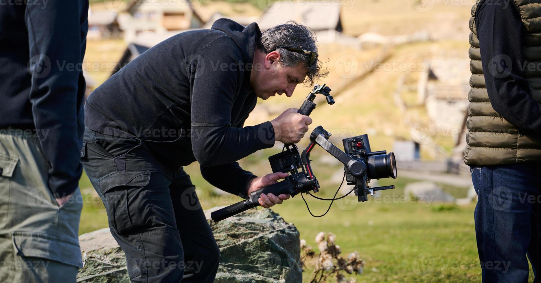 A skilled videographer, equipped with professional gear, captures the essence of nature's beauty, expertly documenting the scenic landscape in a cinematic masterpiece that reflects the seamless blend photo