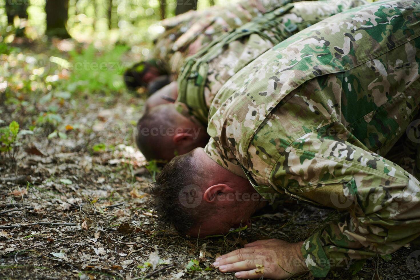 A dedicated group of soldiers engages in Islamic prayer amidst the challenging and perilous conditions of a military operation in dense forested areas photo