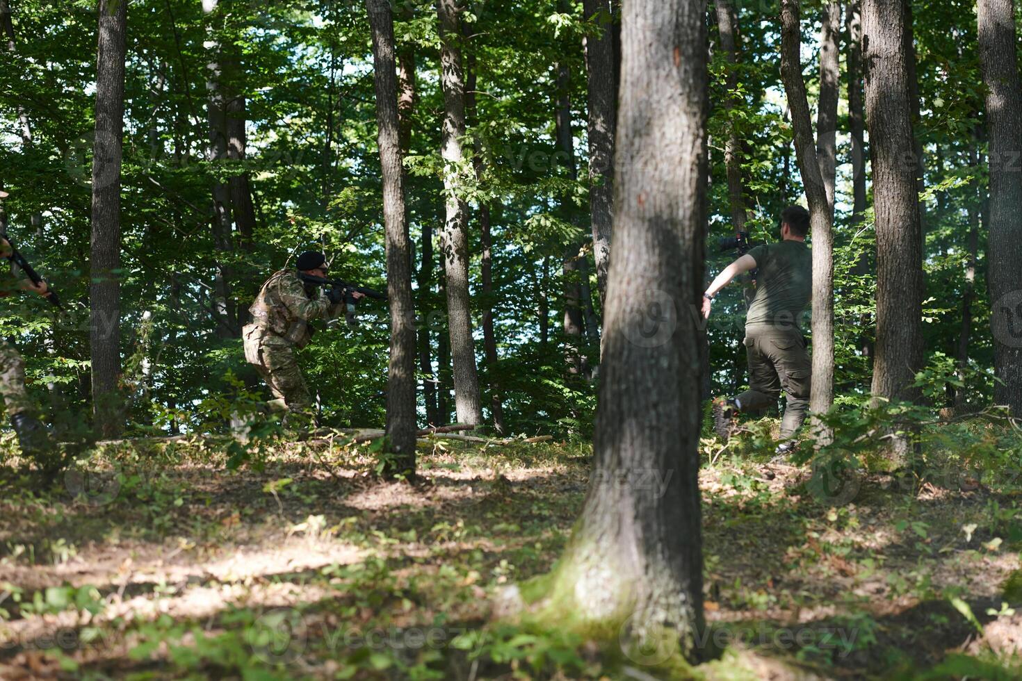 An elite soldier, camouflaged and stealthily navigating through dangerous woodland terrain, executes a covert mission in a secluded forest area photo