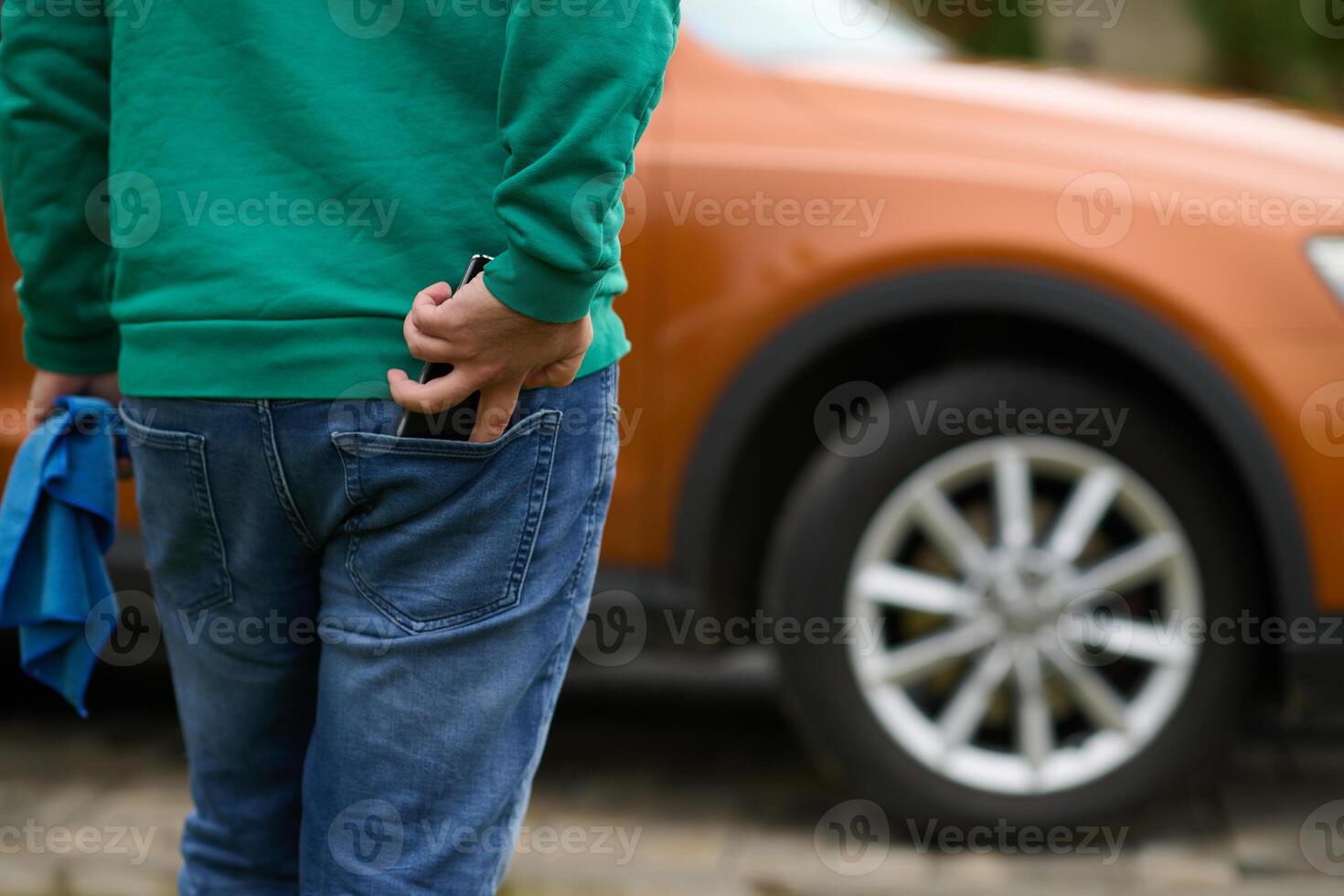 Close Up of a Man Retrieving His Phone from His Jeans Pocket. photo