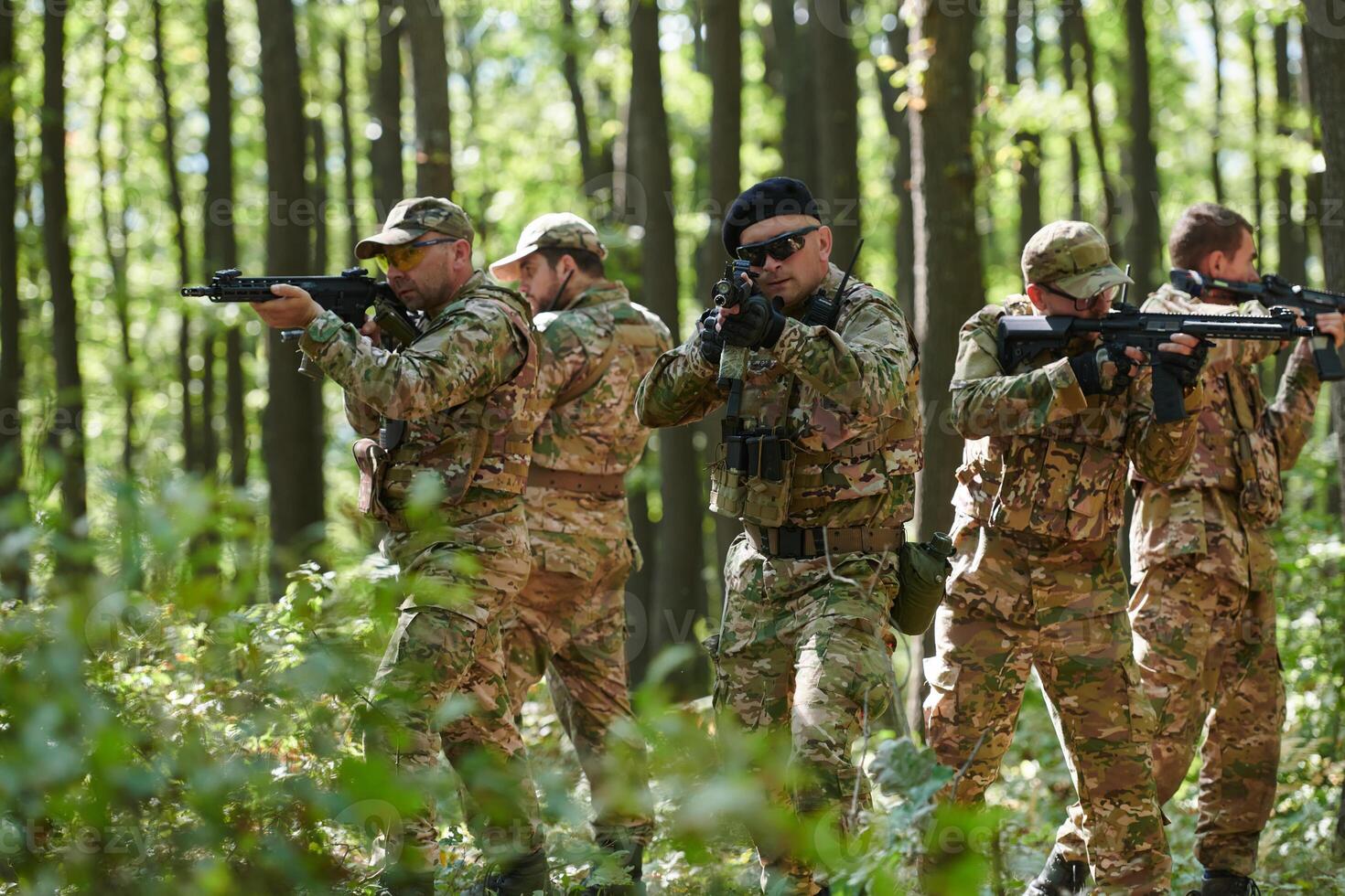 A specialized military antiterrorist unit conducts a covert operation in dense, hazardous woodland, demonstrating precision, discipline, and strategic readiness photo