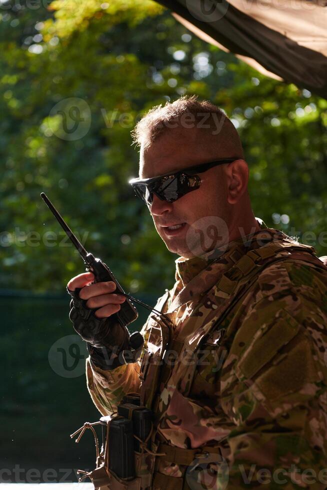 A military major employs a Motorola radio for seamless communication with his fellow soldiers during a tactical operation, showcasing professionalism and strategic coordination photo