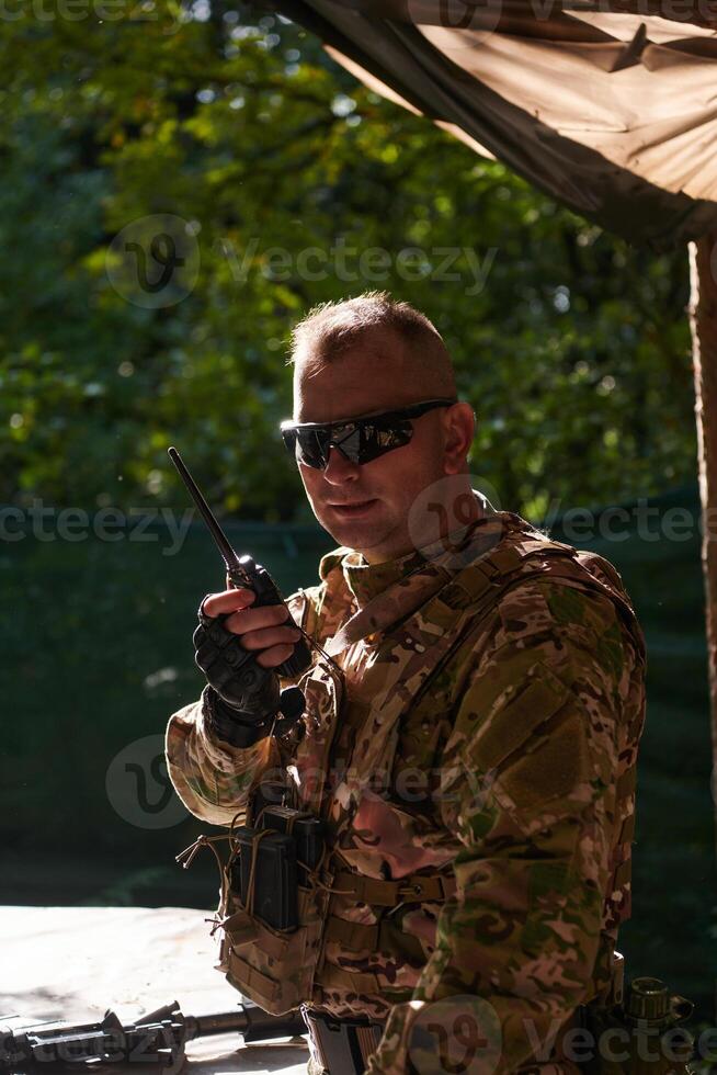 A military major employs a Motorola radio for seamless communication with his fellow soldiers during a tactical operation, showcasing professionalism and strategic coordination photo