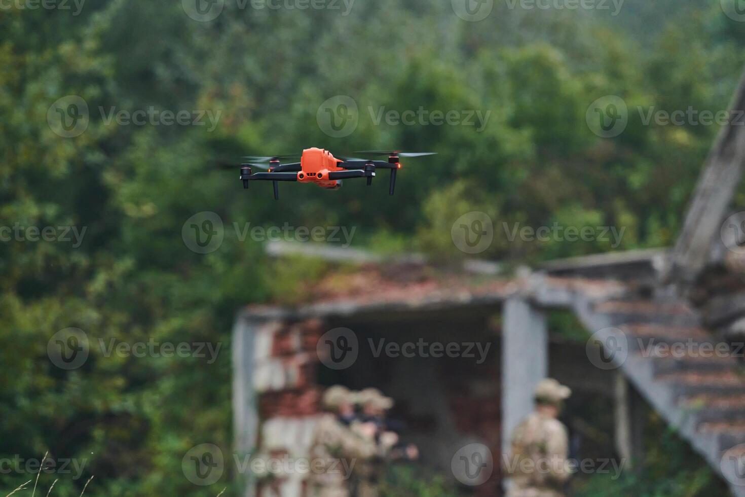 Elite military unit, equipped with state-of-the-art technology including a drone, strategically navigates and surveys dangerous wooded terrain, showcasing their precision, cooperation, and specialized photo