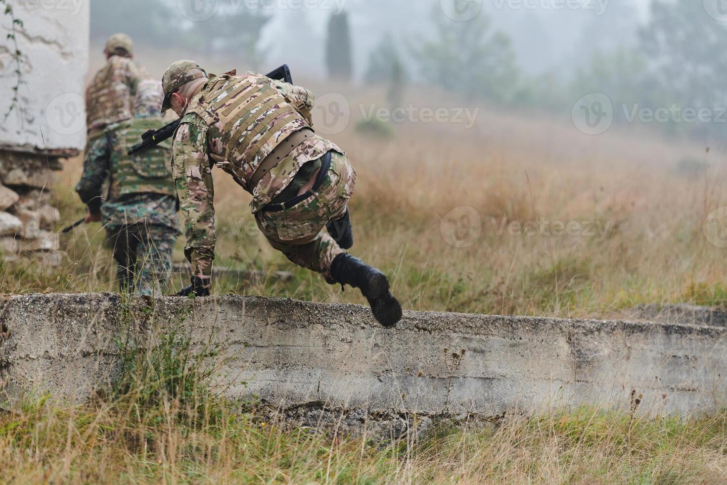 A highly trained elite military unit, clad in camouflage, skillfully navigates through perilous forest terrain, overcoming obstacles and executing a precise and covert mission photo